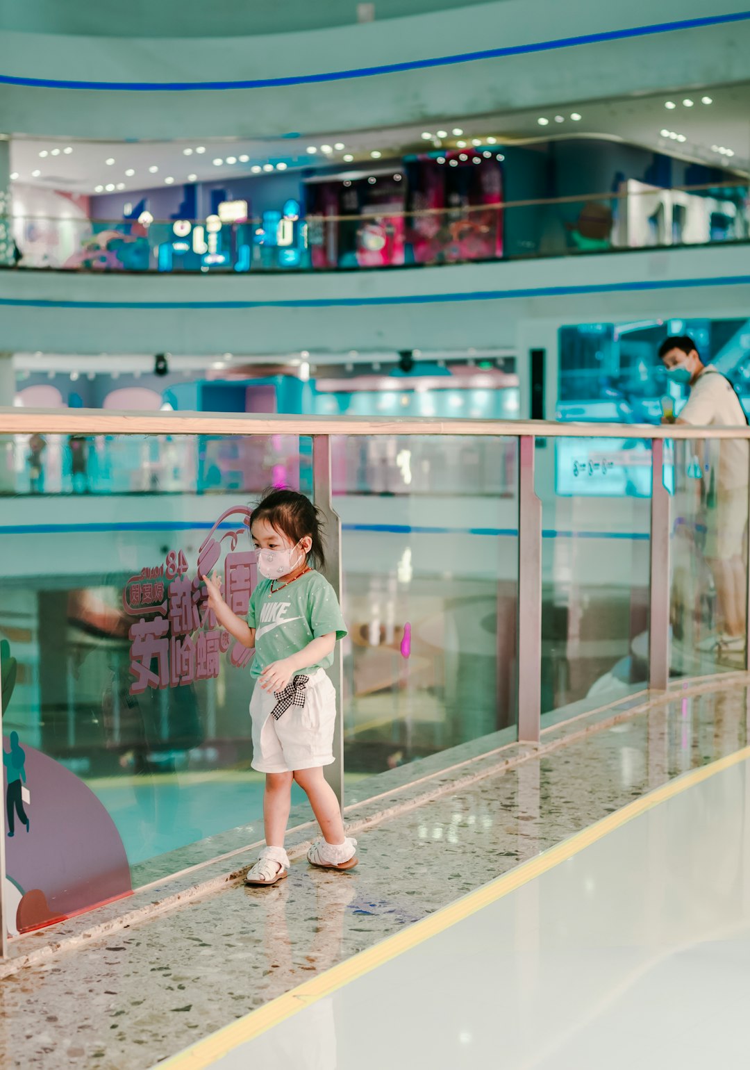 woman in white dress standing beside glass wall