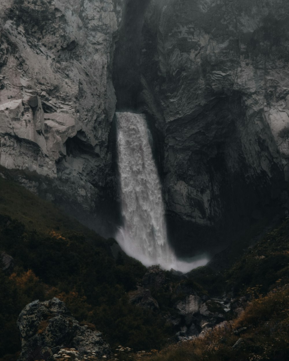 Cascadas entre montañas rocosas grises durante el día