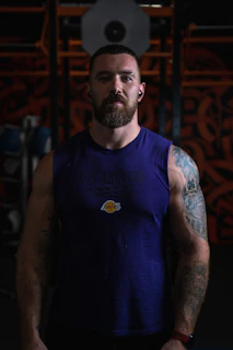 man in blue tank top with tattoo on arm