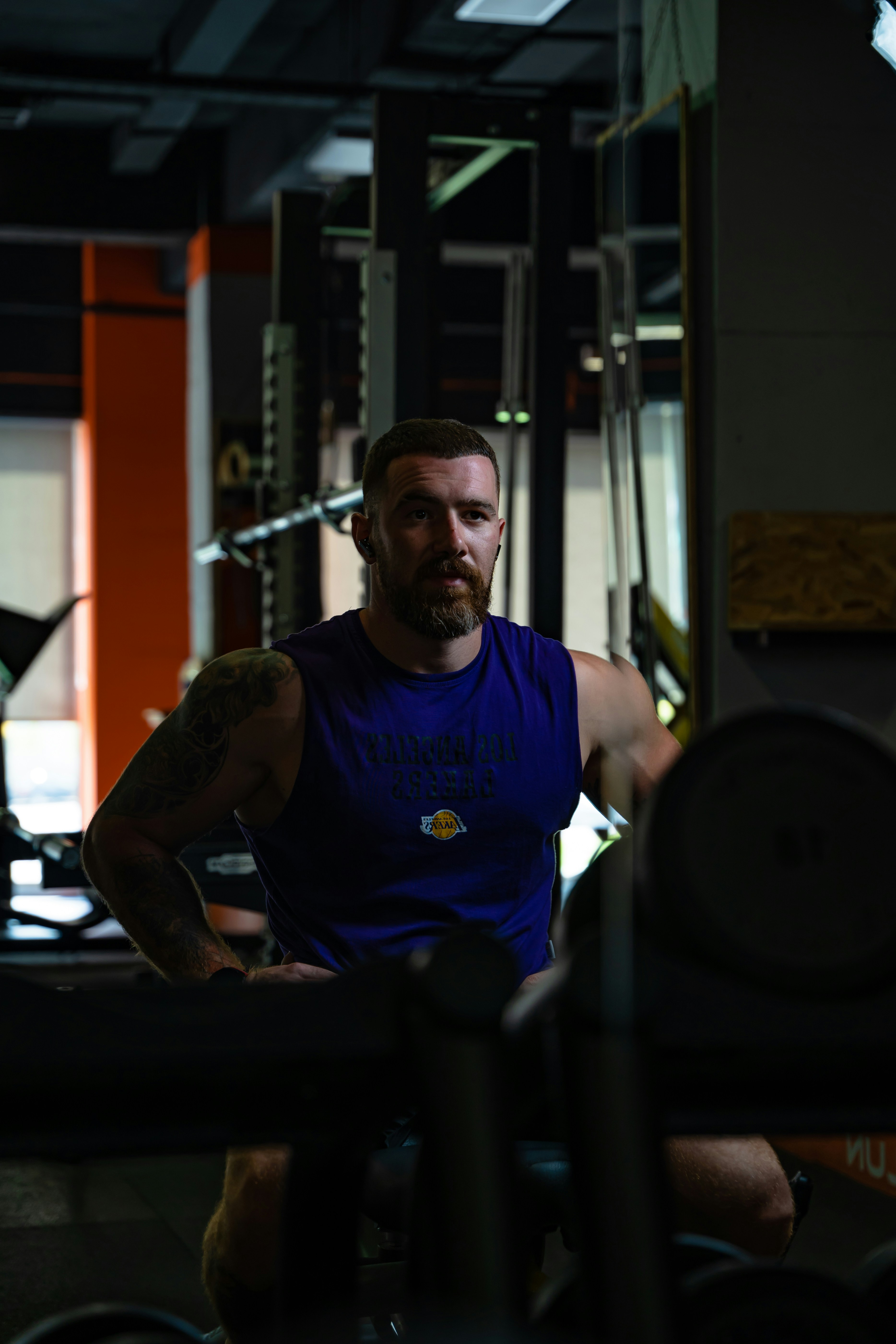 man in blue crew neck t-shirt sitting on black bench press
