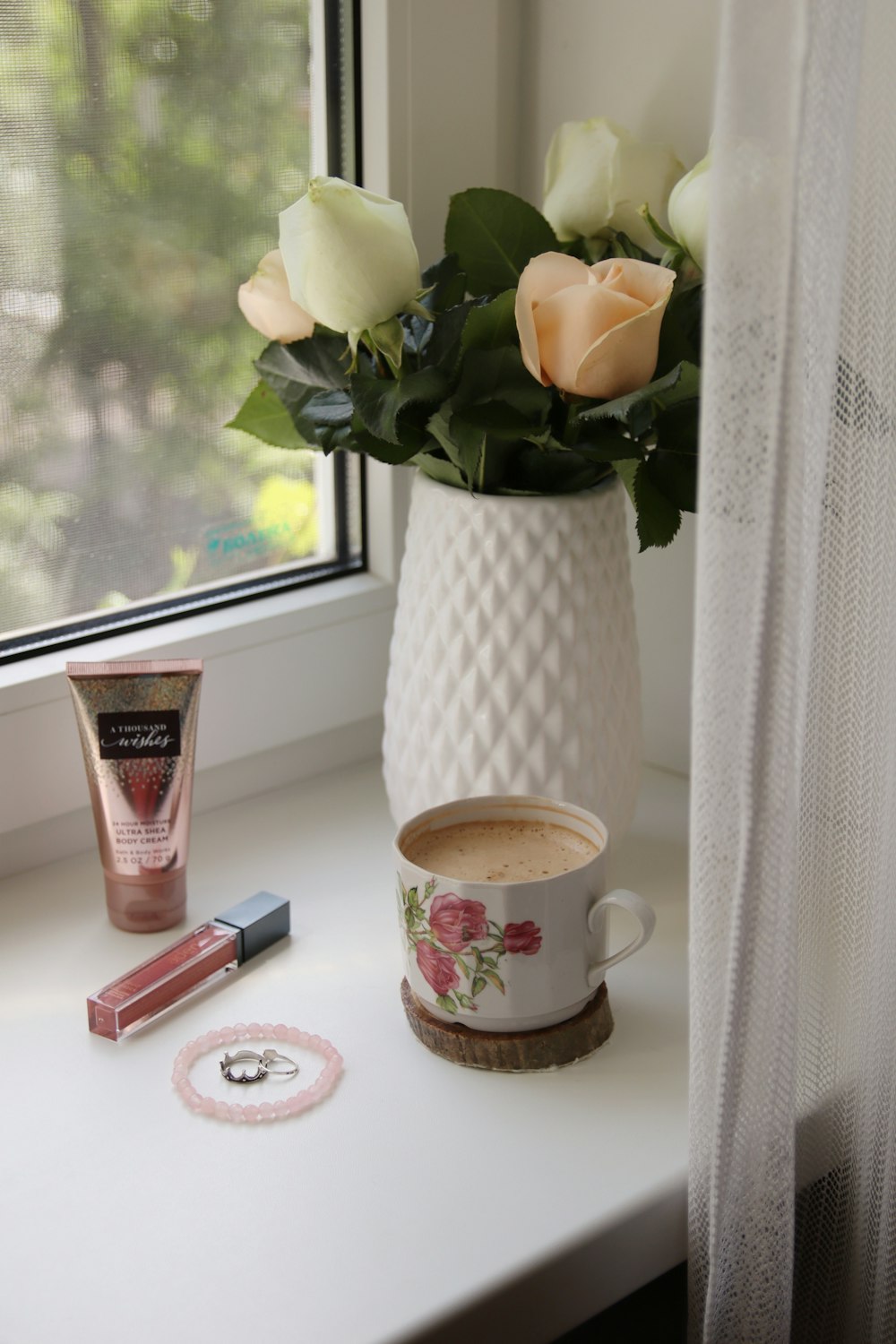 white and pink floral ceramic mug beside white and red disposable lighter