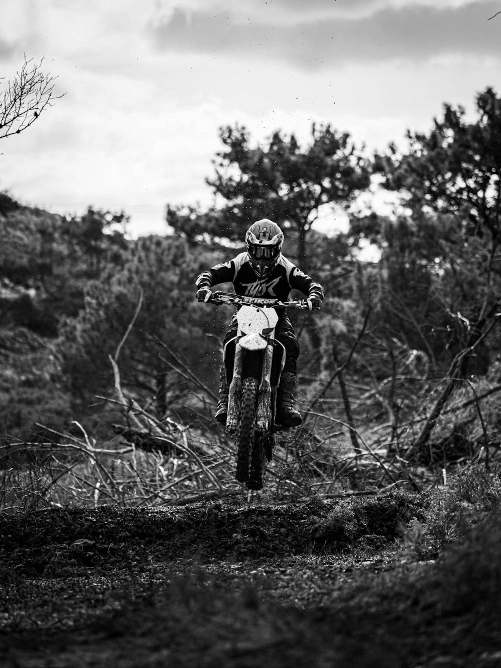 grayscale photo of man riding bicycle