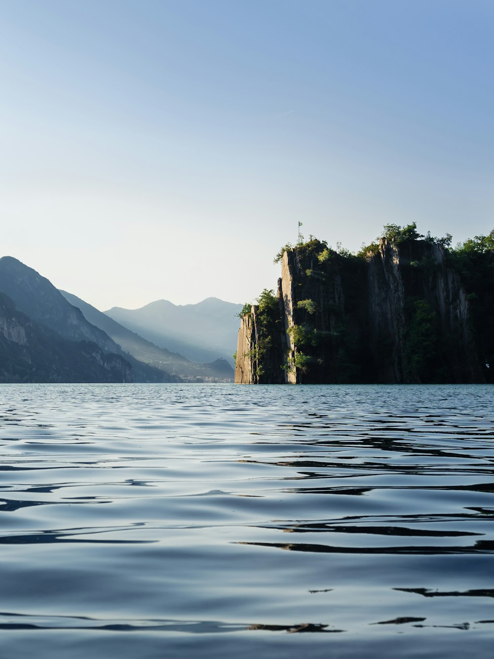 green and brown mountain beside body of water during daytime