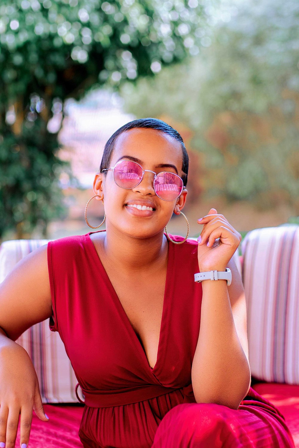 woman in red tank top wearing gold framed aviator sunglasses