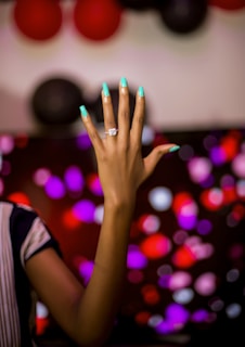 person in black and white shirt with blue manicure