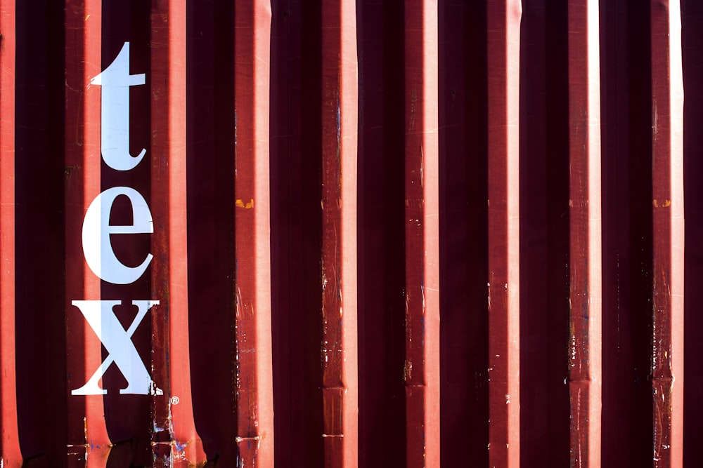 a close up of a red metal structure with the word tex on it