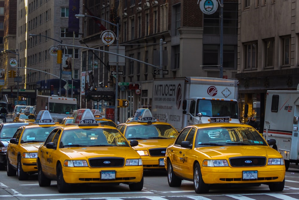 taxi giallo sulla strada vicino all'edificio in cemento bianco durante il giorno