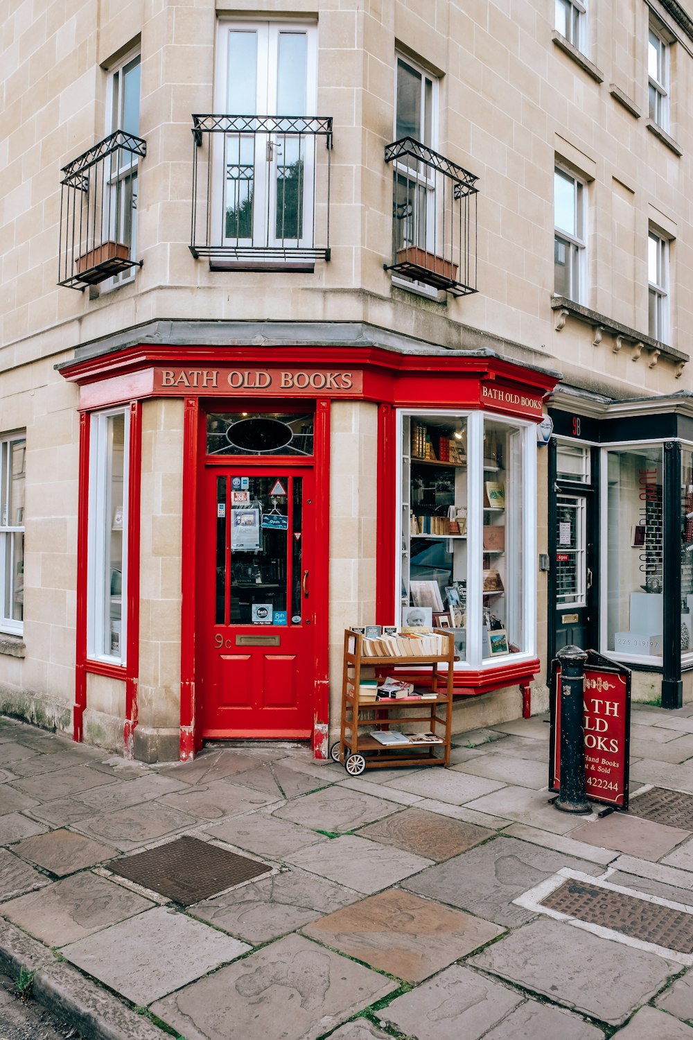 red telephone booth near brown wooden chairs and brown wooden table