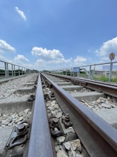 A railway worker inspecting tracks under a bright Australian sky.