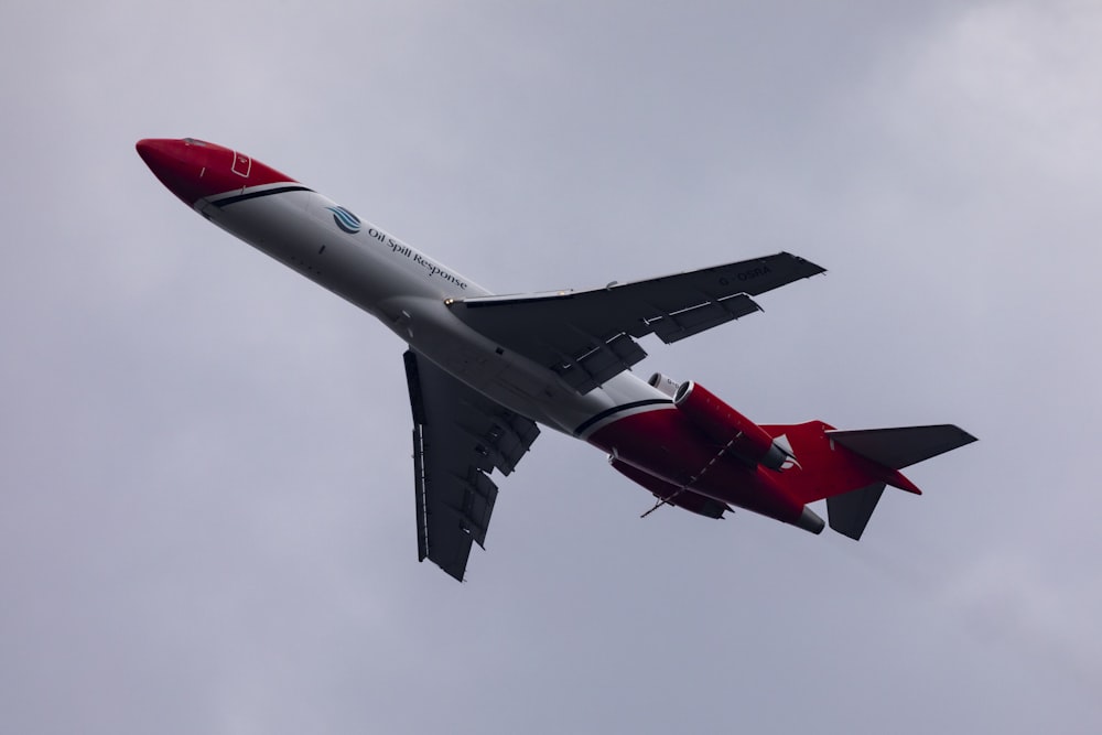 red and white jet plane in mid air