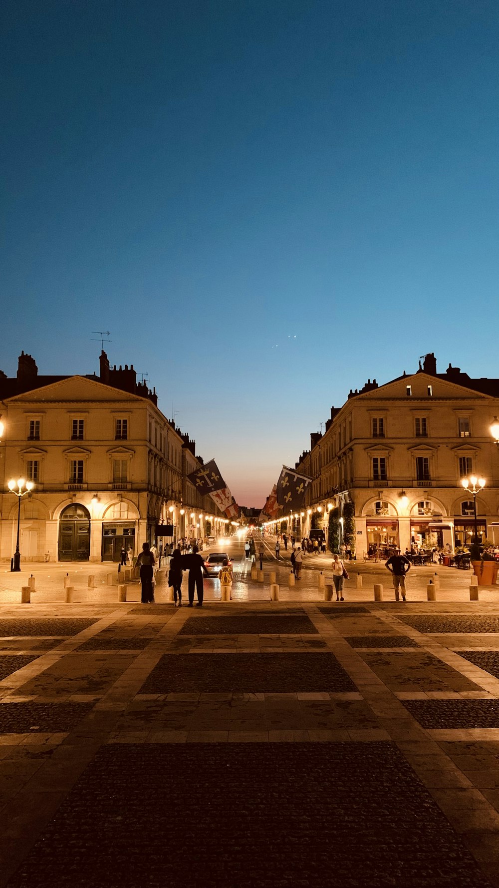 people walking on street near building during night time