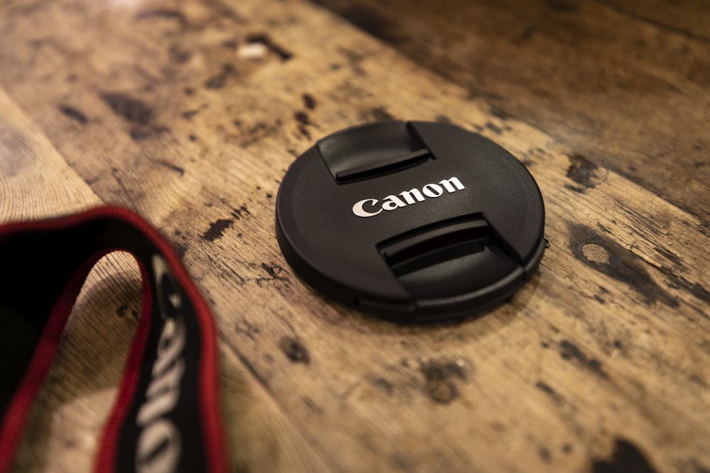 black nikon camera lens cover on brown wooden table