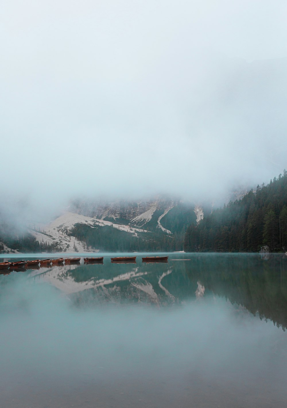 body of water near trees and mountain during daytime