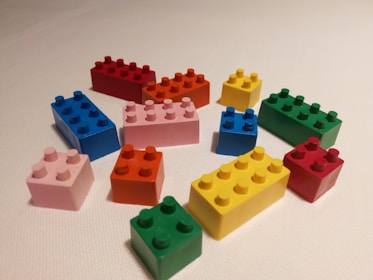 A joyful scene of kids building a castle with various styles of bright building blocks.