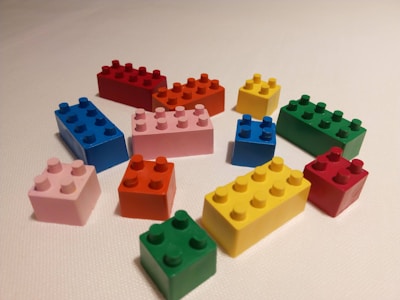 A close-up photo of brightly colored building blocks scattered on a white play surface, showcasing smooth edges and vibrant hues.