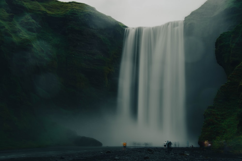 people standing near waterfalls during daytime