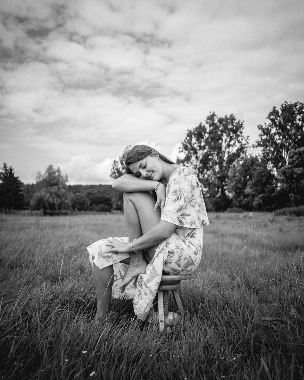 woman in white dress sitting on grass field