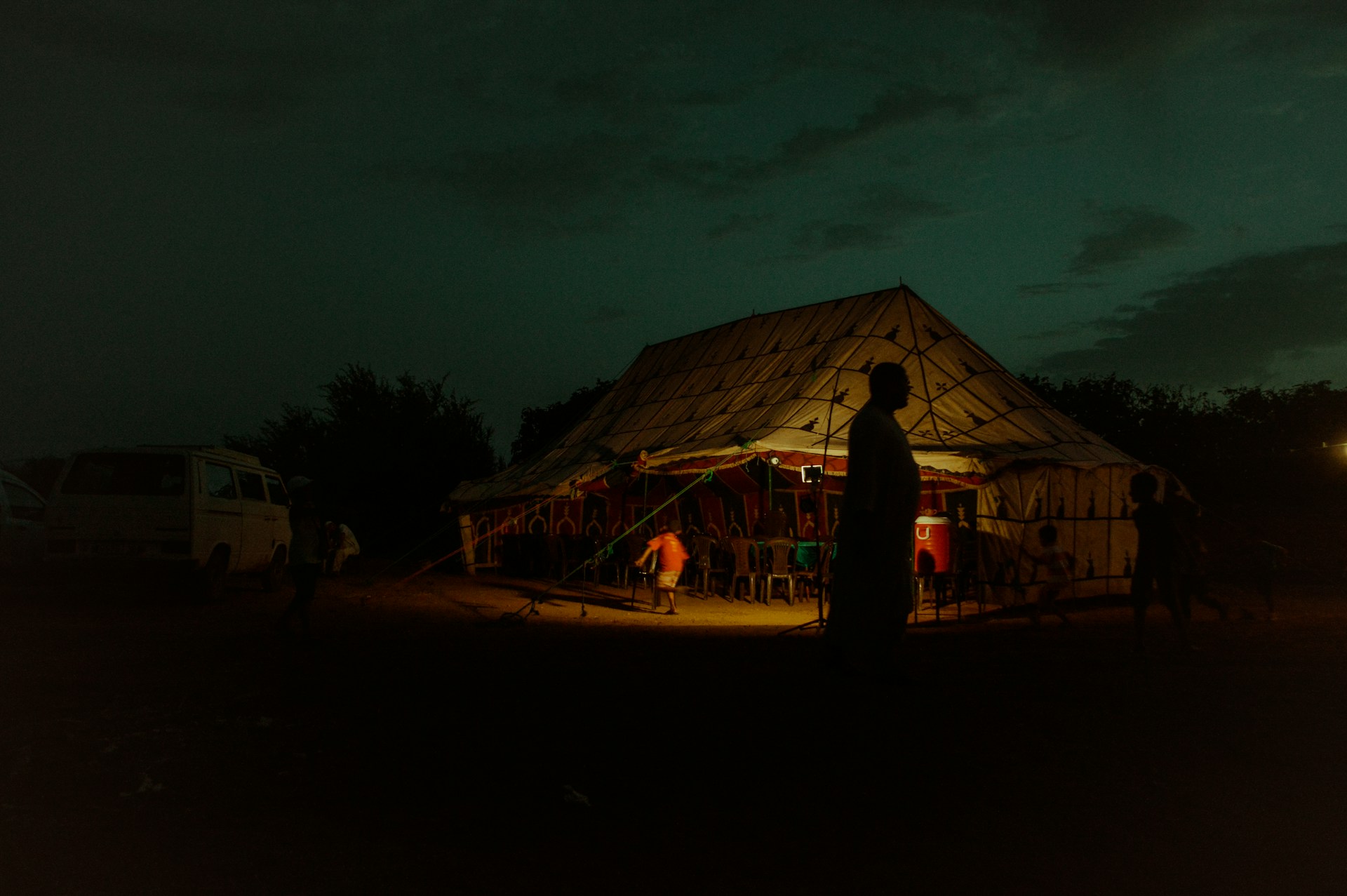 people standing near brown wooden house during night time