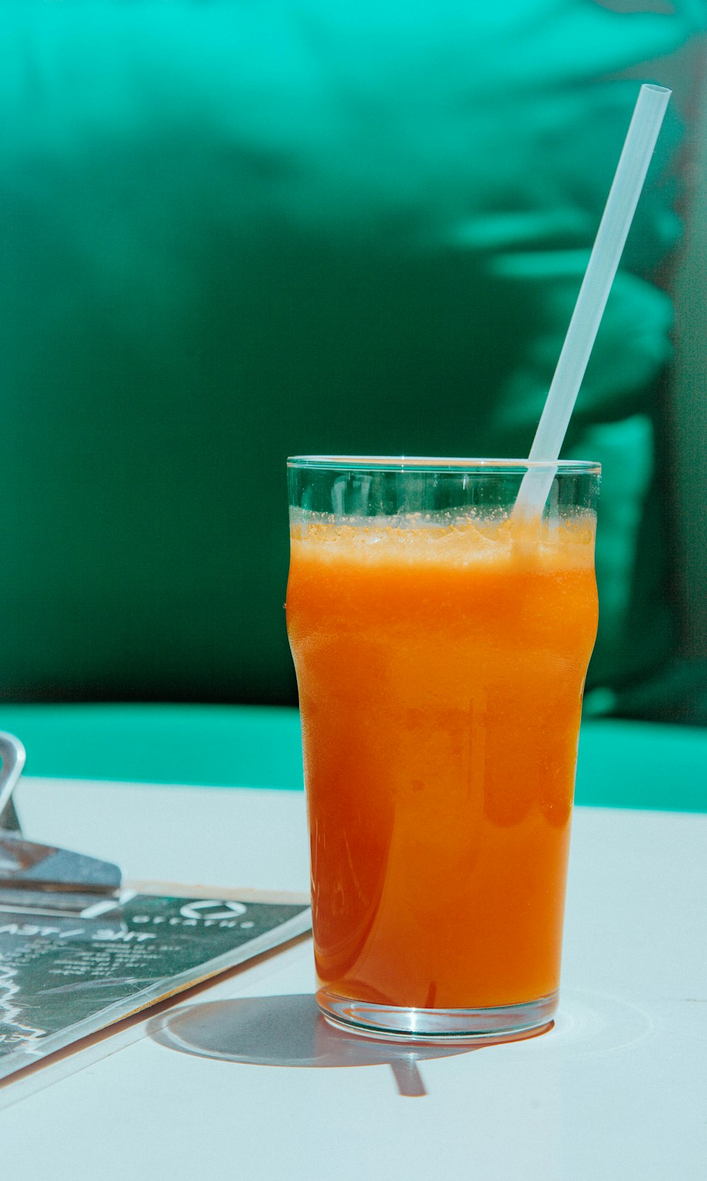 オレンジジュース入り透明なコップ