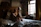 Happy woman sitting on a stylish sognovita bed frame with plush mattress in a sunlit room