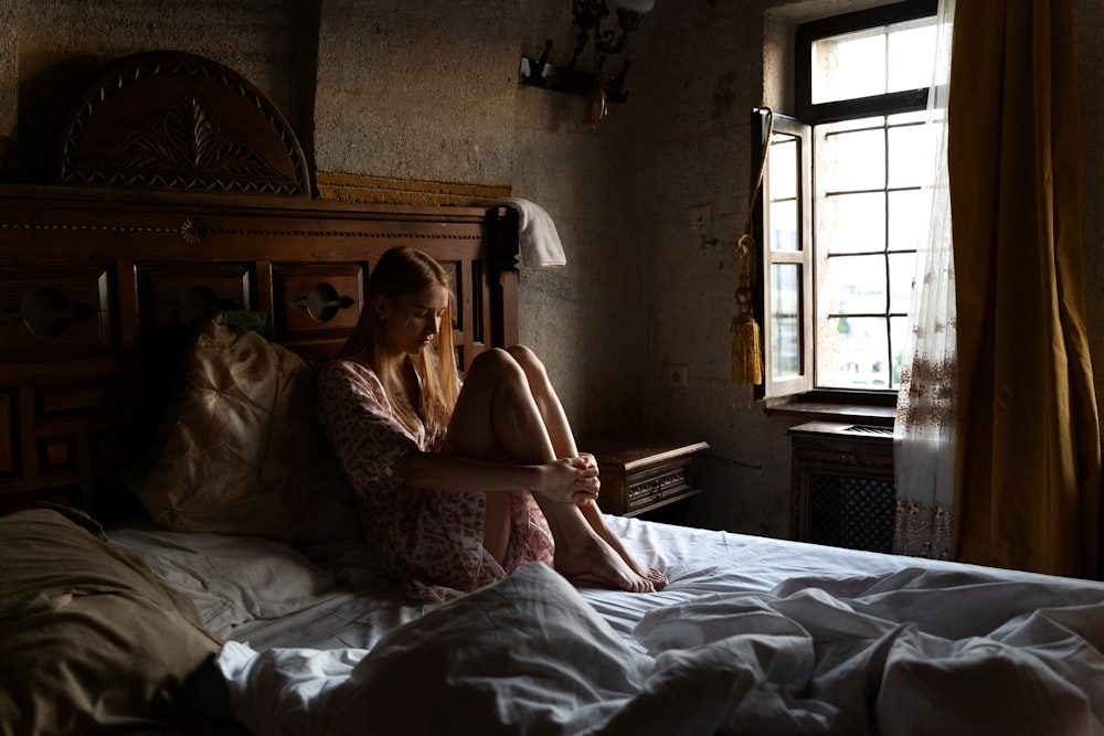 woman in white floral dress lying on bed