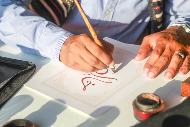 Foto ilustrasi: tangan menulis huruf dengan pena di atas kertas