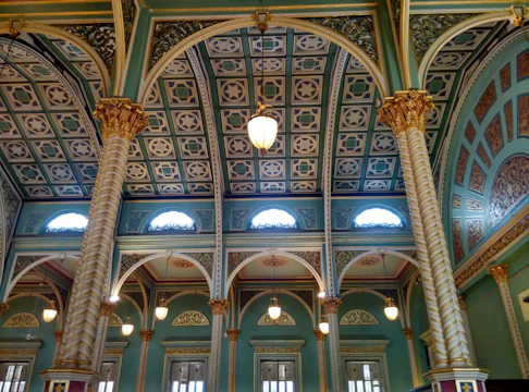 Close-up of champagne gold architectural accents against deep midnight colored walls.