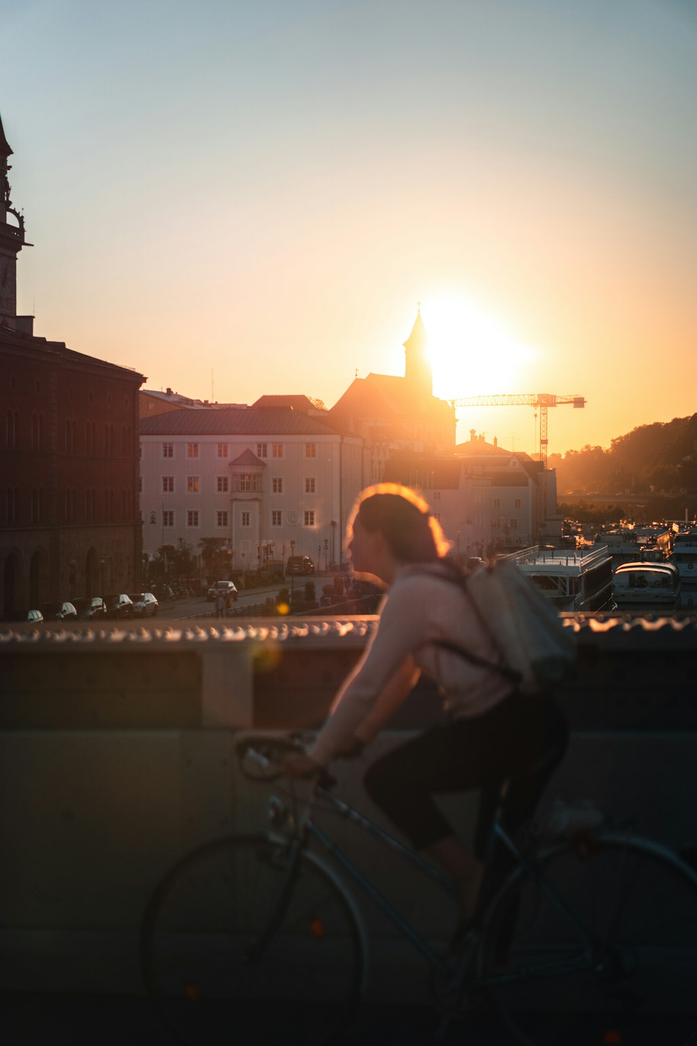 woman in white tank top riding on bicycle during sunset