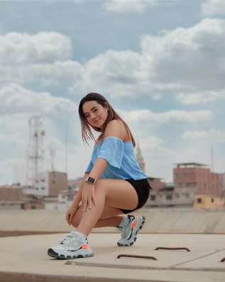 A model lounging on a city rooftop at sunset, wearing a graphic tee with soft pastel clouds and subtle tech-inspired lines.