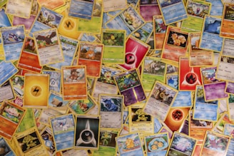 A colorful display of rare and popular Pokémon trading cards spread out on a wooden table with soft natural light.