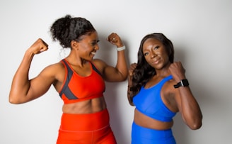 woman in blue sports bra beside woman in blue sports bra