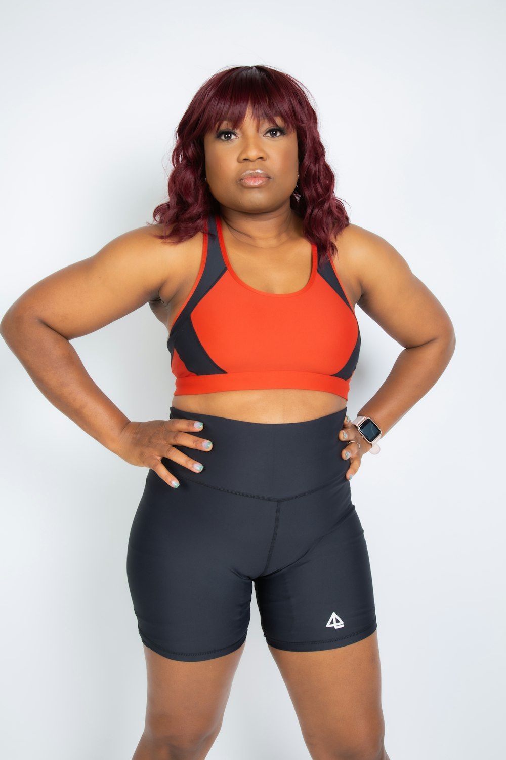 woman in orange sports bra and black leggings