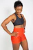 Portrait of a smiling woman in workout clothes, radiating confidence and strength.