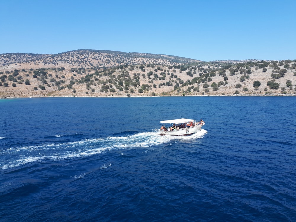 barco branco e vermelho no mar durante o dia
