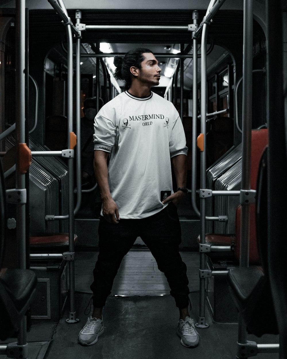 man in white crew neck t-shirt and black pants standing beside red train