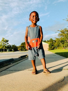 A cheerful toddler wearing a soft, breathable romper playing outdoors on a sunny day.