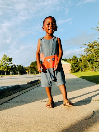 A cheerful toddler wearing a soft, breathable romper playing outdoors on a sunny day.