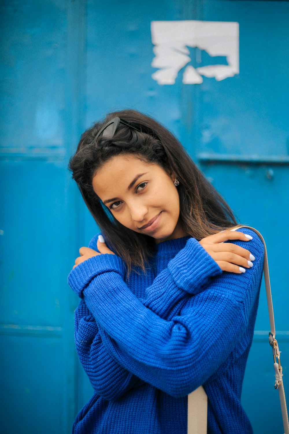 woman in blue sweater holding her hair