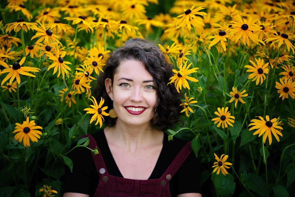 a woman standing in a field of yellow flowers