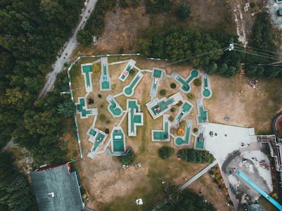 A sunny day view of the Volkspark Minigolf course with families playing and colorful obstacles.