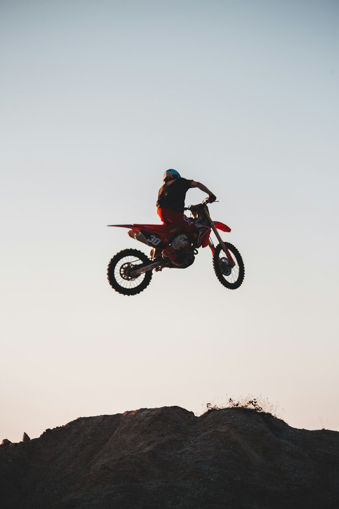 man in black jacket riding on black and red motocross dirt bike