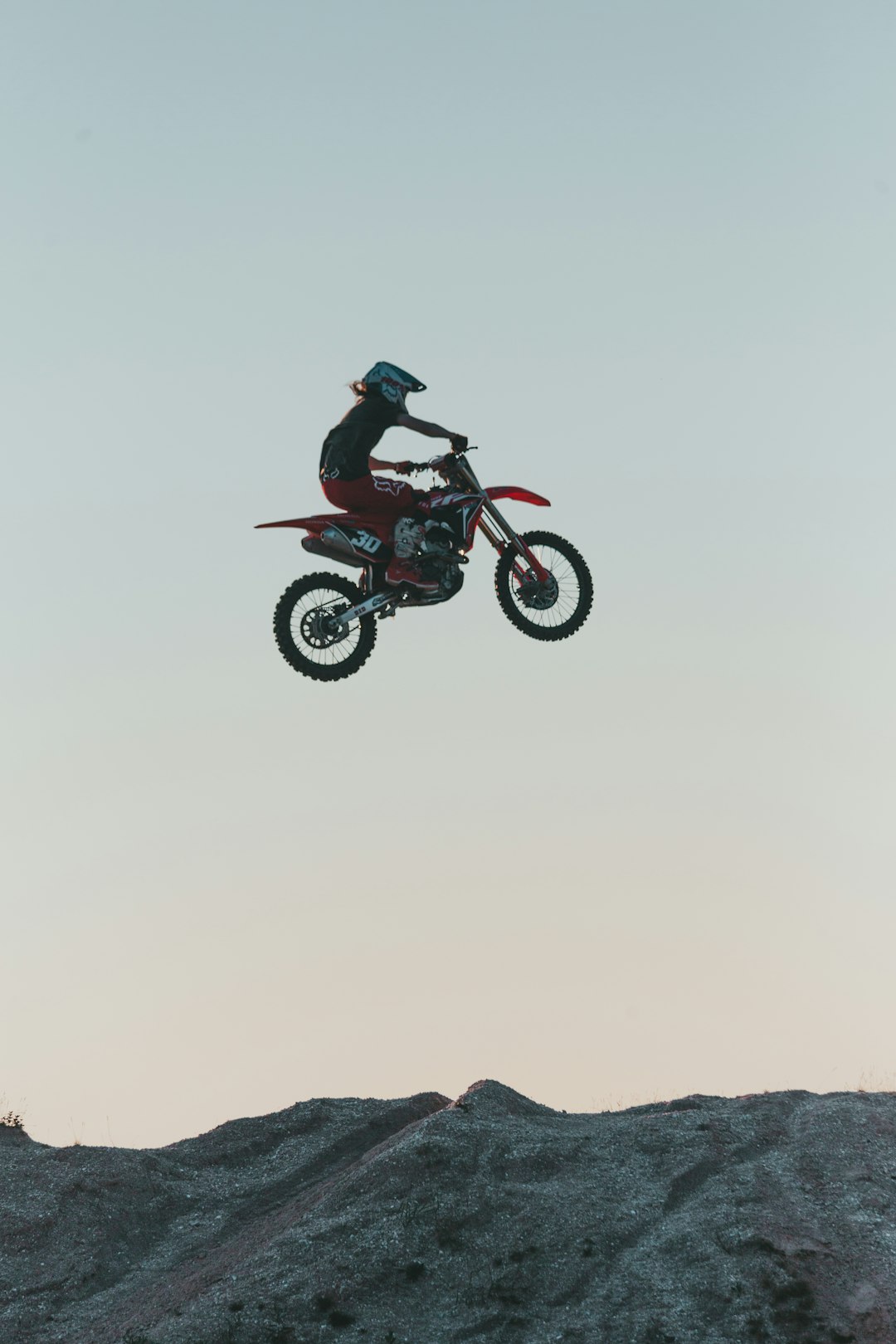 man riding motocross dirt bike on snow covered field during daytime