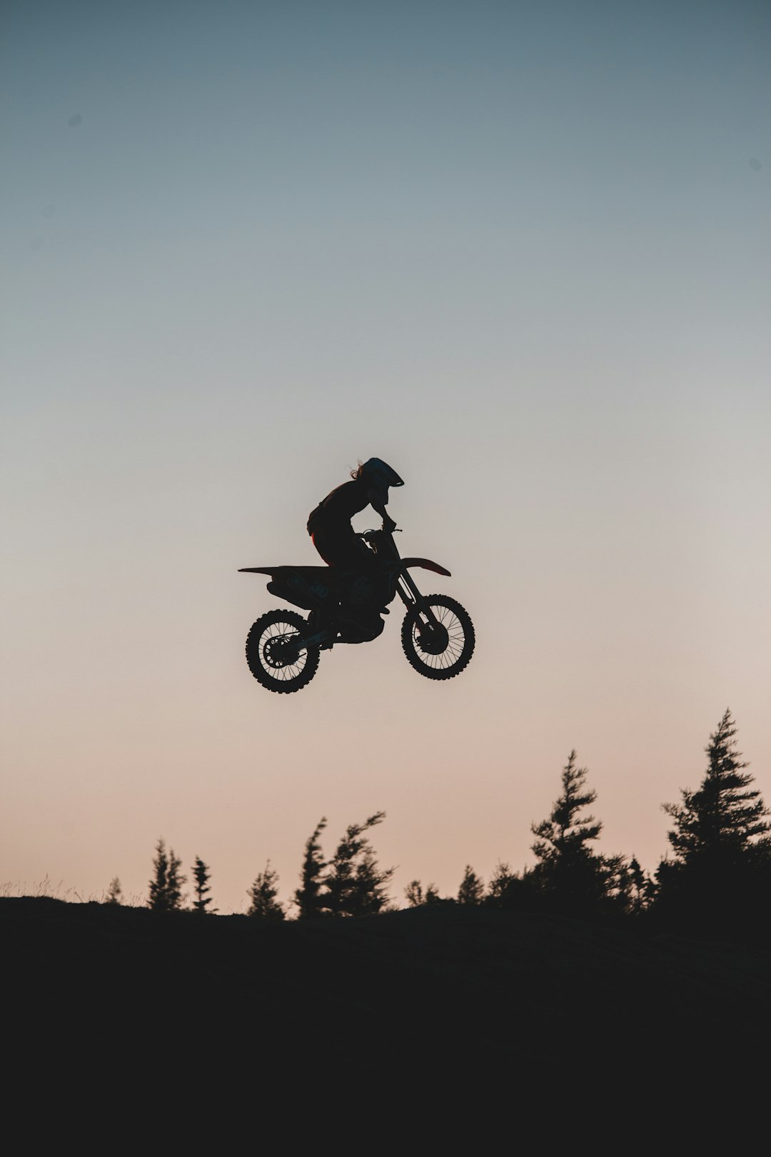 man riding motocross dirt bike on mid air during daytime