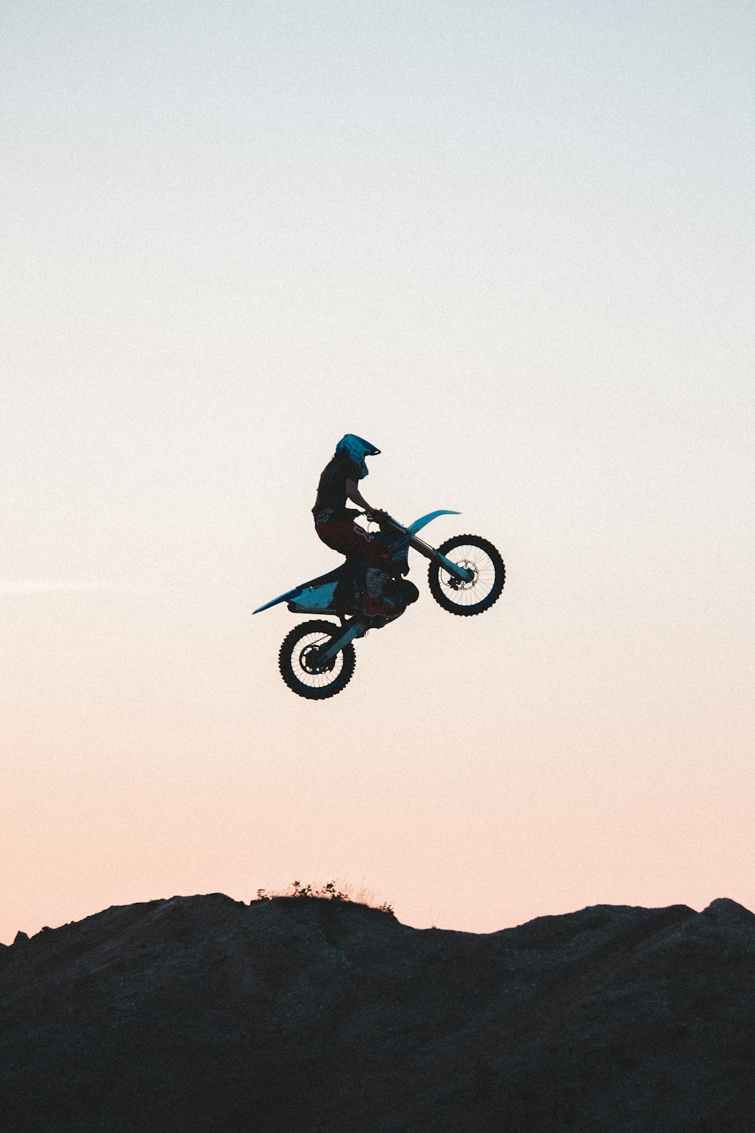 man riding motocross dirt bike on mid air during daytime