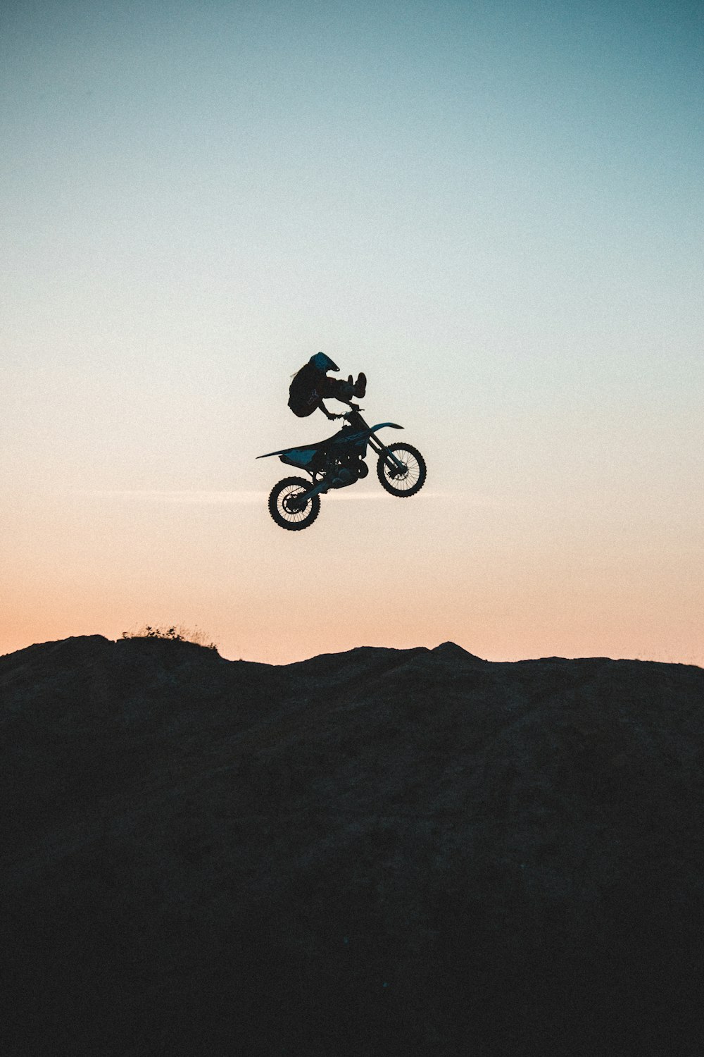 man riding on black motorcycle on brown mountain during daytime