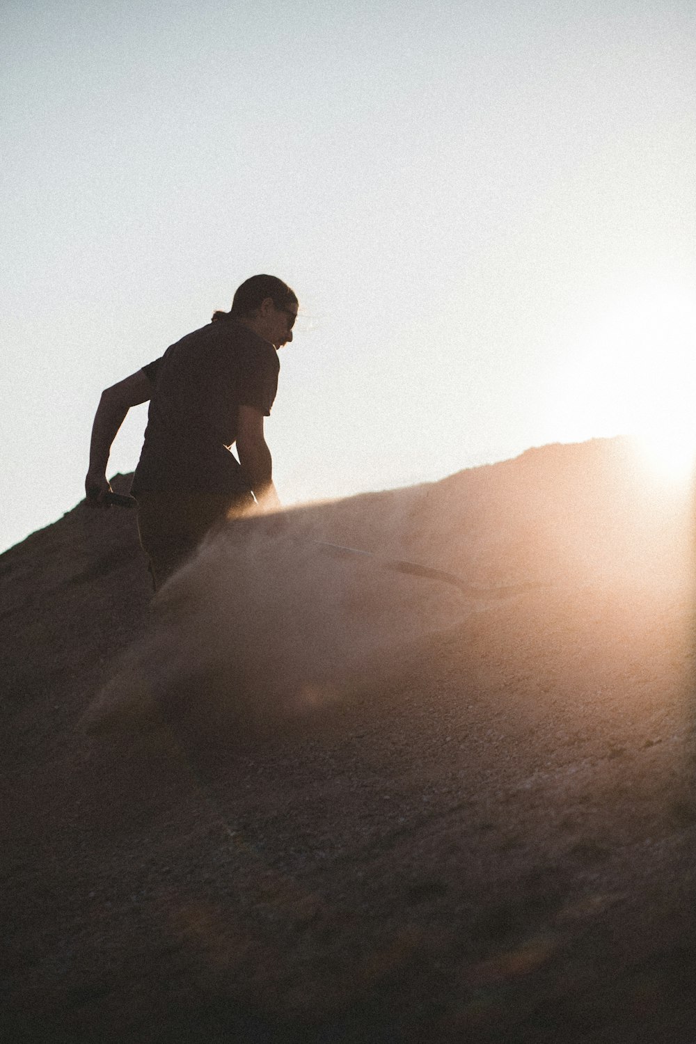 man in black shirt and pants standing on brown sand during daytime