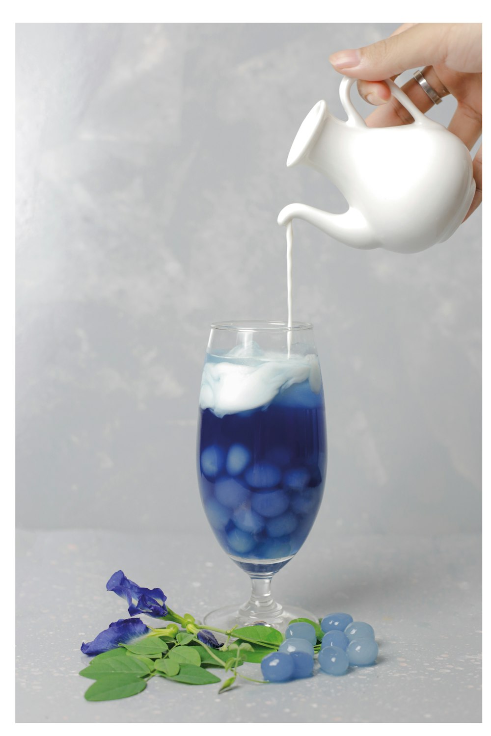 white ceramic teapot pouring water on clear glass