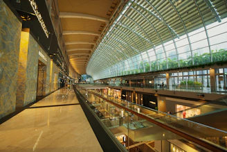 Interior shot of a bright, contemporary shopping arcade with glass ceilings and stylish retail units.
