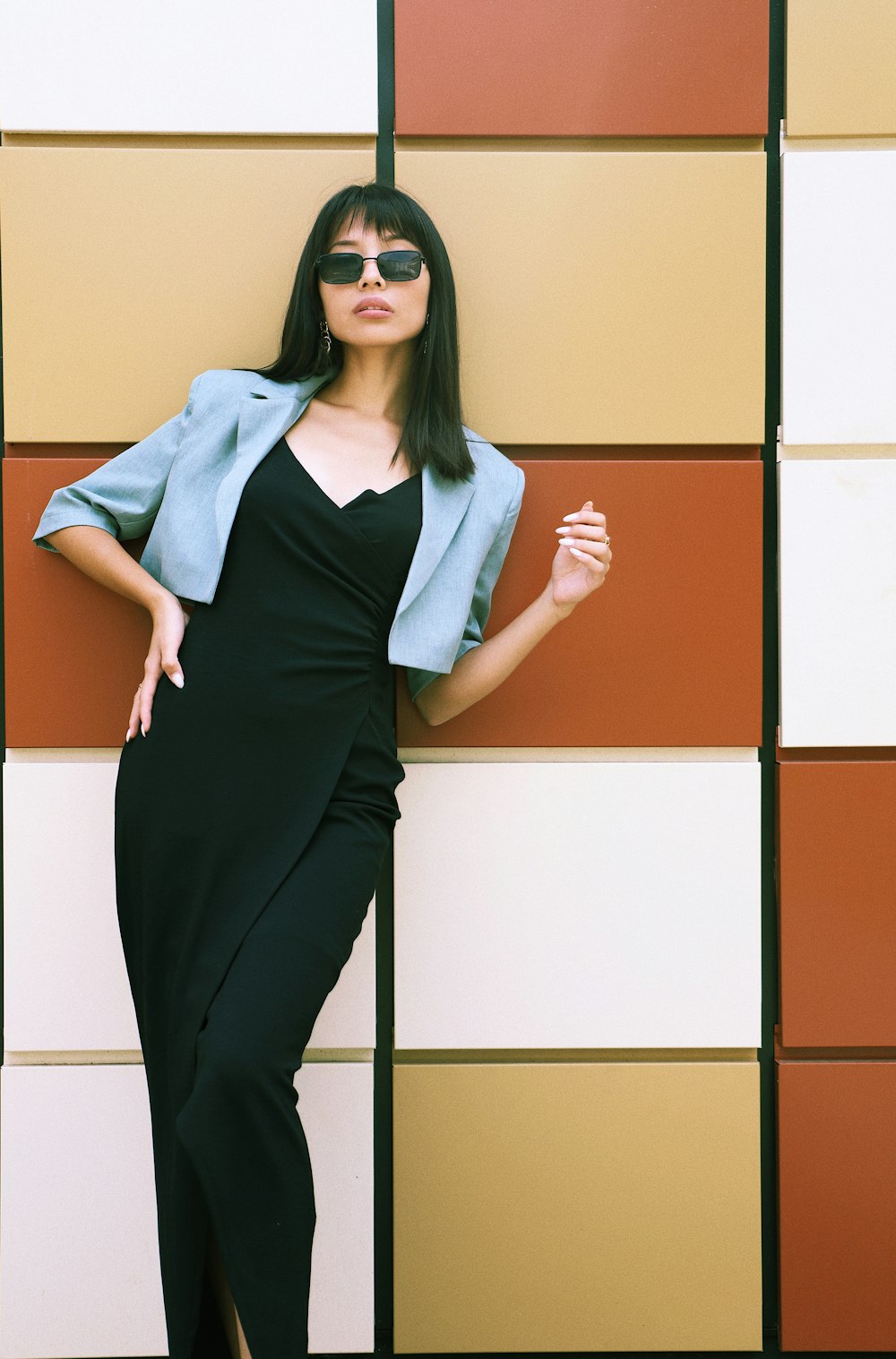 woman in black sleeveless dress and gray cardigan