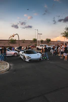 A group of automotive creators collaborating outdoors with cameras and drones.